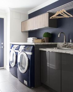 a washer and dryer in a laundry room with cabinets on either side of the washer