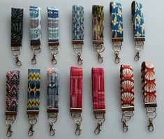 several colorful lanyards are lined up on a white surface with key chains attached to them