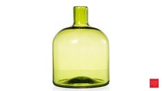 a green glass bottle sitting on top of a white table