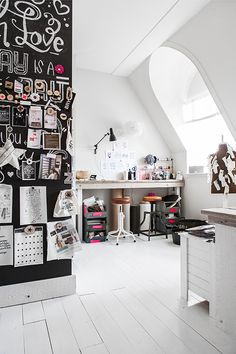 a white room with lots of pictures on the wall and desks in front of it