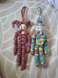 two crocheted stuffed animals laying next to each other on top of a bed