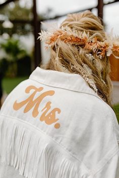 the back of a woman's head with feathers in her hair and an msu t - shirt on