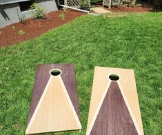 two pieces of wood sitting on top of grass next to each other in front of a house