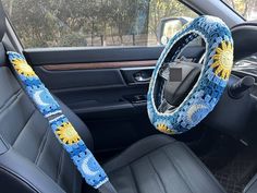 the interior of a car with a steering wheel cover and sunflowers on it