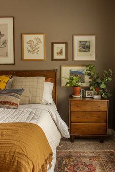 a bed sitting in a bedroom next to a dresser with pictures on the wall above it