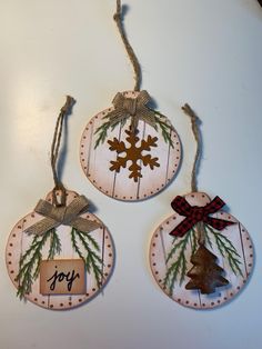 three wooden ornaments are hanging on a white wall with the words joy and a christmas tree