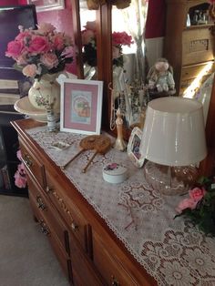 a dresser with pink flowers and pictures on it