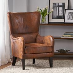 a brown leather chair sitting on top of a rug