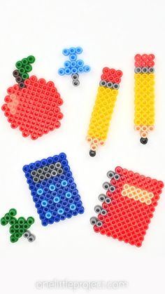 the beads are made to look like apples and an apple with two pencils on it