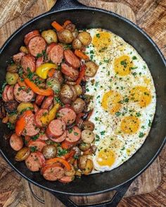 eggs, sausage and potatoes in a skillet on a wooden table