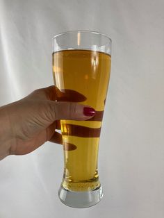 a woman's hand holding a glass of beer