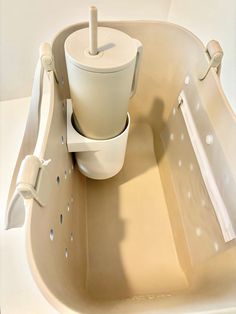 a white toilet sitting inside of a bath tub next to a plunger and hand rail