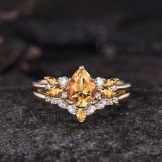 an orange and white diamond ring sitting on top of a rock