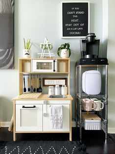 a small kitchen with white cabinets and black rugs on the floor, including a coffee maker