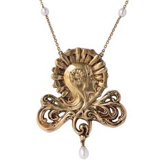 Baume creation - Unique piece. Necklace in 18 carat yellow gold, eagle head hallmark. Featuring a woman’s head, her hair blends into an openwork design engraved beneath. She wears a golden flower in her hair. The design is completed with an oriental baroque cultured white pearl pendant. From each side of this design gold links attach it to a belcher chain interspersed on each side with 4 oriental baroque cultured white pearls. This pendant has a round spring clasp. Total length: 43,5 cm, height: 5.5 cm, width at widest: 4.8 cm. Total weight of the jewel: 22.16 g. Our opinion: A modern and feminine reinterpretation of this original Art Nouveau design. Specialized in antique and creation jewelry since 1975, we deliver all our jewel with their certificate of authenticity, written by our certi Art Nouveau Motif, Pearl Gold Necklace, Art Nouveau Necklaces, French Art Nouveau, Art Nouveau Pendant, Gold Eagle, Art Nouveau Design, Gold Pearl Necklace, Eagle Head