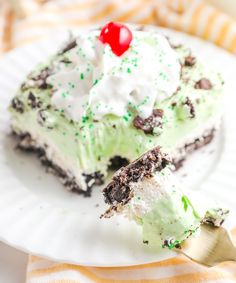 a piece of ice cream cake on a white plate with a fork in front of it