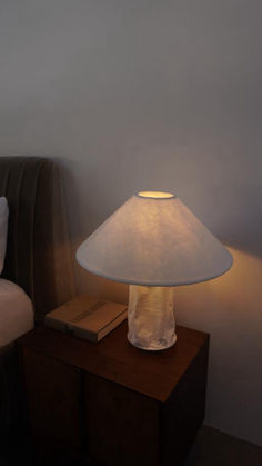 a lamp sitting on top of a table next to a bed