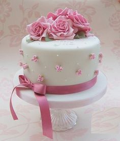 a white cake with pink roses on top