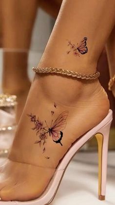 a woman's foot with butterfly tattoos on her left ankle and gold chain around the ankles