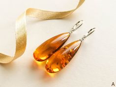 "Natural Baltic amber cognac color earrings is a perfect choice for classy style admirers! Shaped in drop form these earrings look delicate yet fancy. MATERIALS AND SIZE: Stone: 100% Natural Baltic Amber Findings: Sterling silver 925 Earrings A: Weight: 10,3 g (0,36 oz) Bead size: 4,3 cm (1,69 in) x 1,6 cm (0,63 in) Total earring length: 6,3 cm ( 2,48 in) Earrings B: Weight: 9,4 g (0,33 oz) Bead size: 4,9 cm (1,93 in) x 1,7 cm (0,67 in) Total earring length: 6,8 cm ( 2,68 in) PLEASE NOTE: All ou Luxury Amber Drop Earrings, Modern Amber Earrings For Formal Occasions, Modern Amber Earrings For Formal Events, Amber Teardrop Earrings As A Gift, Amber Teardrop Earrings Gift, Amber Teardrop Drop Earrings For Gift, Handmade Elegant Teardrop Earrings, Handmade Orange Earrings For Formal Occasions, Orange Teardrop Jewelry For Formal Occasions