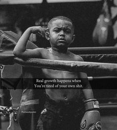 a young boy standing next to a boxing ring