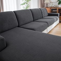 a large gray couch sitting in front of a window