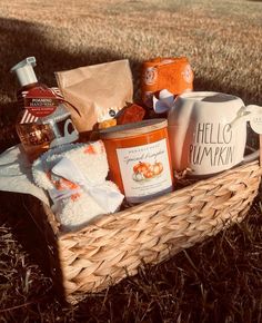 a basket filled with lots of food and condiments on top of the grass