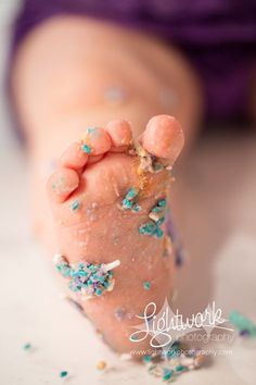 a baby's foot covered in confetti and sprinkles on top of it