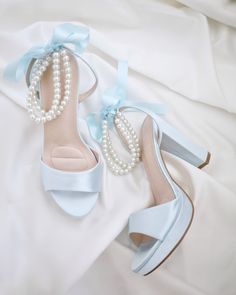 An all time classic and elegance with simplicity of satin block heels sandal adorned with double pearls ankle strap for a sweet and romantic look. Perfect for brides, bridesmaids, prom night, date night, and definitely a highlight on every special occasions. The delicate pearl beads are placed carefully by hand made to order to create a graceful classic bridal shoe. DETAILS: HEELS: 4 inches COLORS AVAILABLE: Ivory, White, Light Blue,  Black, Champagne UPPER: Synthetic upper and lining MATERIALS: Manmade outsole ORIGIN: Imported STYLE NAME: ATHENA  Not sure of which size to purchase? Shoes measurements are as follow: (Please note measurements taken the length of inside of shoe from toe to heel) SIZE 5 - 9" SIZE 6 - 9.25" SIZE 7 - 9.5" SIZE 8 - 9.875" SIZE 9 - 10.25" SIZE 10 - 10.50"  SIZE 1 White Heels With Blue Flowers, Light Blue High Heels Quinceanera, Wedding Shoes Bride Something Blue, Wedding Shoes Light Blue, Bride Platform Heels, Light Blue Prom Heels, Prom Shoes Short Heel, Light Blue Prom Shoes, Blue Shoes For Wedding