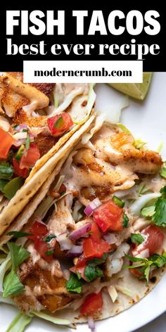 fish tacos with lettuce, tomatoes and onions on a white platter