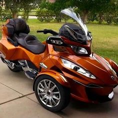 an orange motorcycle is parked on the sidewalk