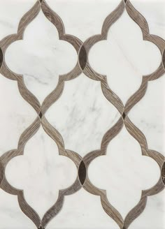 a white marble tile with an intricate design in the middle and brown trimmings