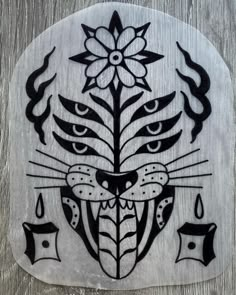 a wooden plaque with an image of a cat's face and flowers on it