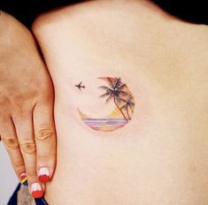 a woman's stomach with a small palm tree tattoo on it