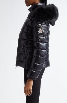 The label's elevated mountaineering aesthetic takes a glamorous twist in this glossy nylon puffer boasting plush down insulation and a detachable hood traced with removable faux fur. Two-way front-zip closure Stand collar; removable hood with faux-fur trim Front zip pockets; sleeve snap-flap patch pocket Nylon lining, with 90% down, 10% feather fill (Armenia) 100% nylon with 100% polyester faux fur Dry clean Made in Armenia Designer Clothing Luxury Black Puffer Jacket With Zipper Closure, Luxury Black Puffer Jacket With Detachable Hood, Luxury Black Down Puffer Jacket, Luxury Down Puffer Jacket For Outdoor, Luxury Fitted Puffer Jacket For Outdoor, Luxury Down Puffer Jacket With Detachable Hood, Luxury Nylon Puffer Jacket For Cold Weather, Luxury Nylon Puffer Jacket For Outdoor, Mountaineering Aesthetic