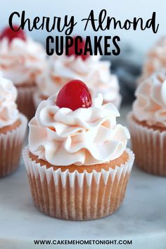 cupcakes with white frosting and cherries on top