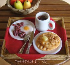 a plate with waffles, eggs and bacon on it next to a cup of coffee