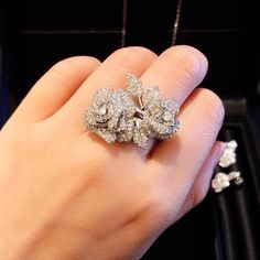 a woman's hand holding a diamond ring