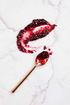 a spoon with some food on it next to a piece of bread and cranberry sauce