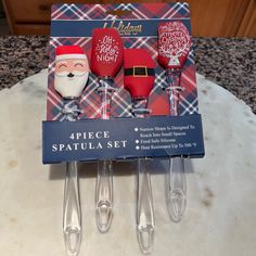 three christmas themed wine glasses sitting on top of a table next to some forks and spoons