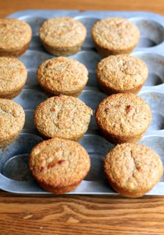 several muffins are placed in a baking pan on a wooden table, ready to be eaten