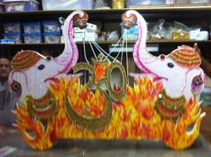 an elaborately decorated wooden sign depicting the hindu god and his two flamings on fire