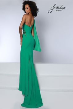 a woman in a long green dress with an open back and cape on her shoulder