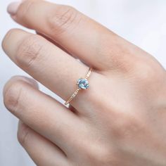 a woman's hand with a blue diamond ring on top of her left hand