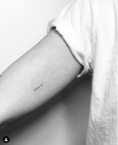 a woman's arm with the word love tattooed on her left arm, in black and white