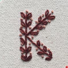 an embroidered letter k is shown on a piece of fabric