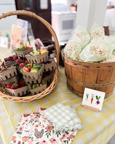 a table topped with baskets filled with fruit and veggies next to a basket of popcorn