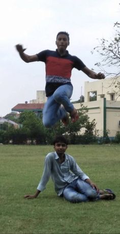 two young men are playing frisbee in the grass outside on a cloudy day