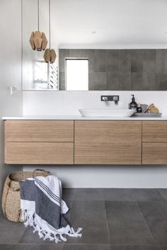 a bathroom with a sink, mirror and towel on the floor in front of it