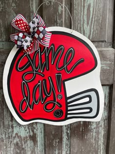 a red and white sign that says some day on it with a bow hanging from the front